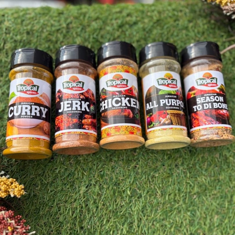 Five Tropical Spices seasoning bottles, including Curry, Jerk, Chicken, All Purpose, and Season To Di Bone.