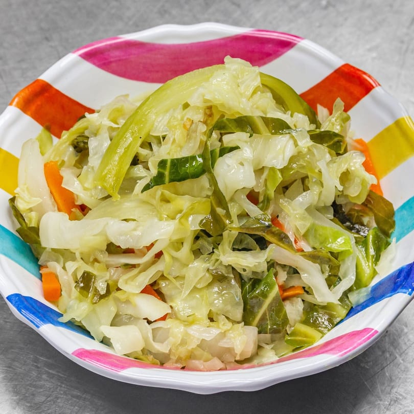 A colorful bowl of steamed cabbage, collard greens, and carrots from Andreas Caribbean & Seafood Restaurant.